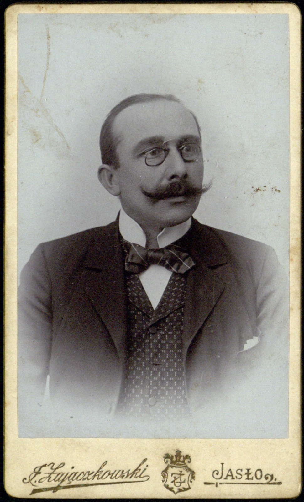 portret mężczyzny w binoklach z podkręconym wąsem