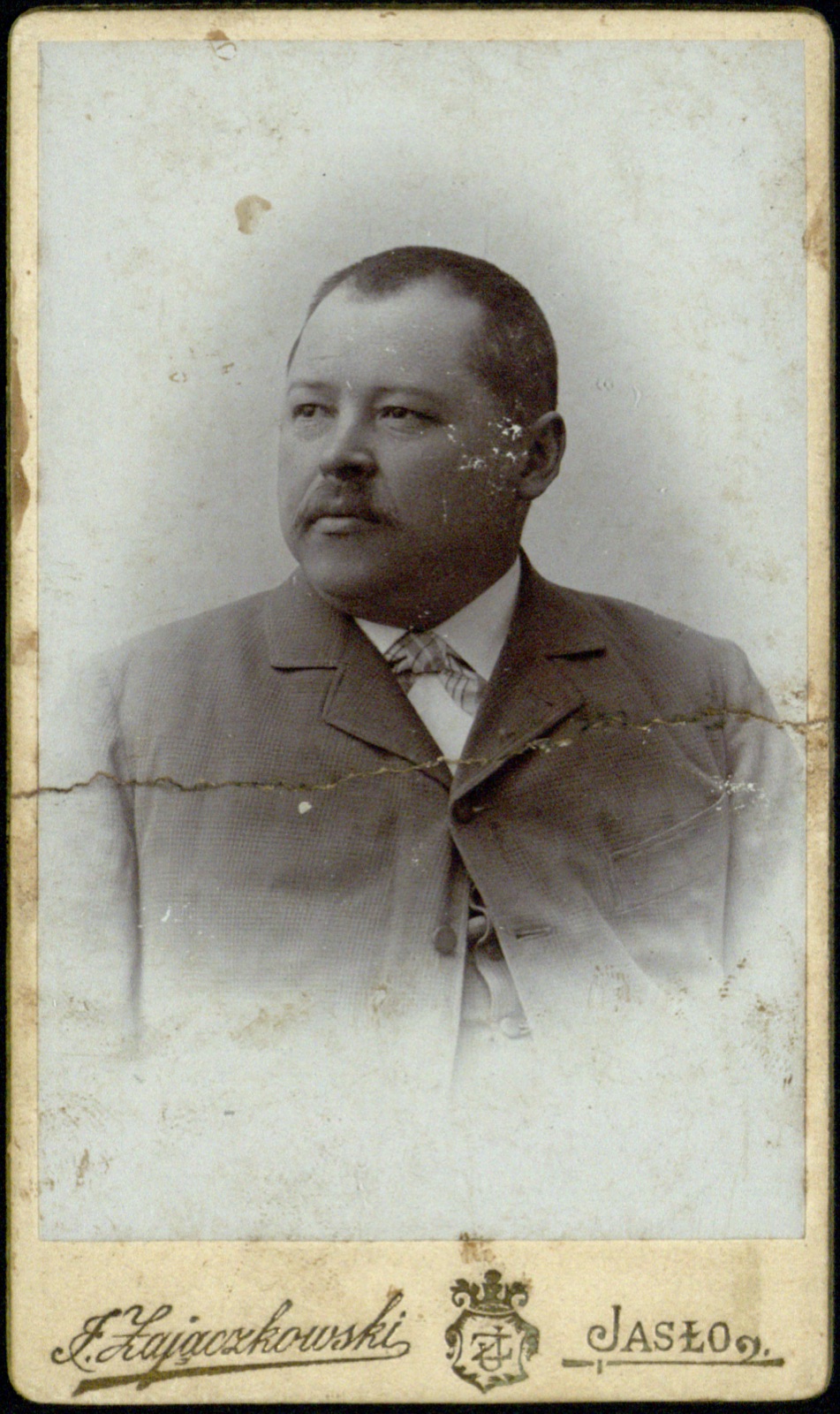 portret tęgiego mężczyzny z wąsem