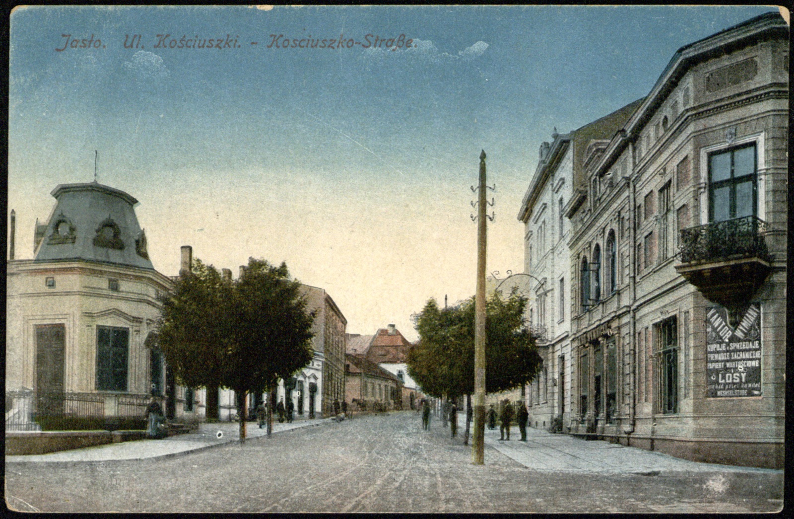 ul. Kościuszki (Kosciuszko-Straße), barwna, ożywiona scena uliczna z szyldami (kantor wymiany / „Losy”); nieobiegowa