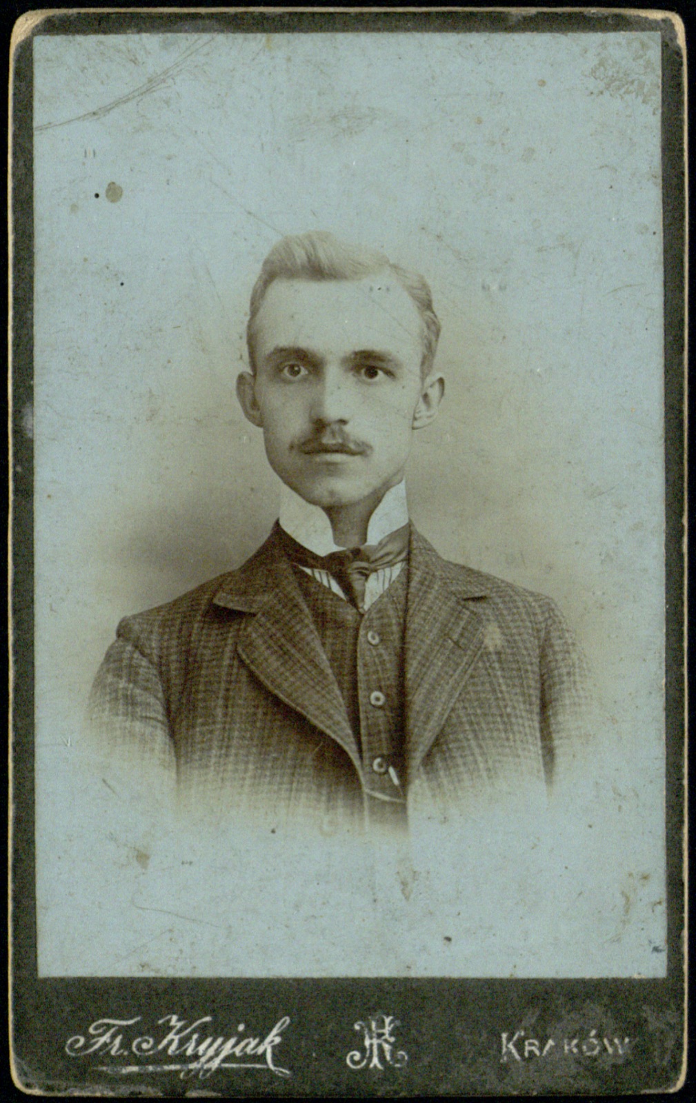 portret młodego mężczyzny w kraciastym garniturze (fotografia gabinetowa, ok. 1905–1918)