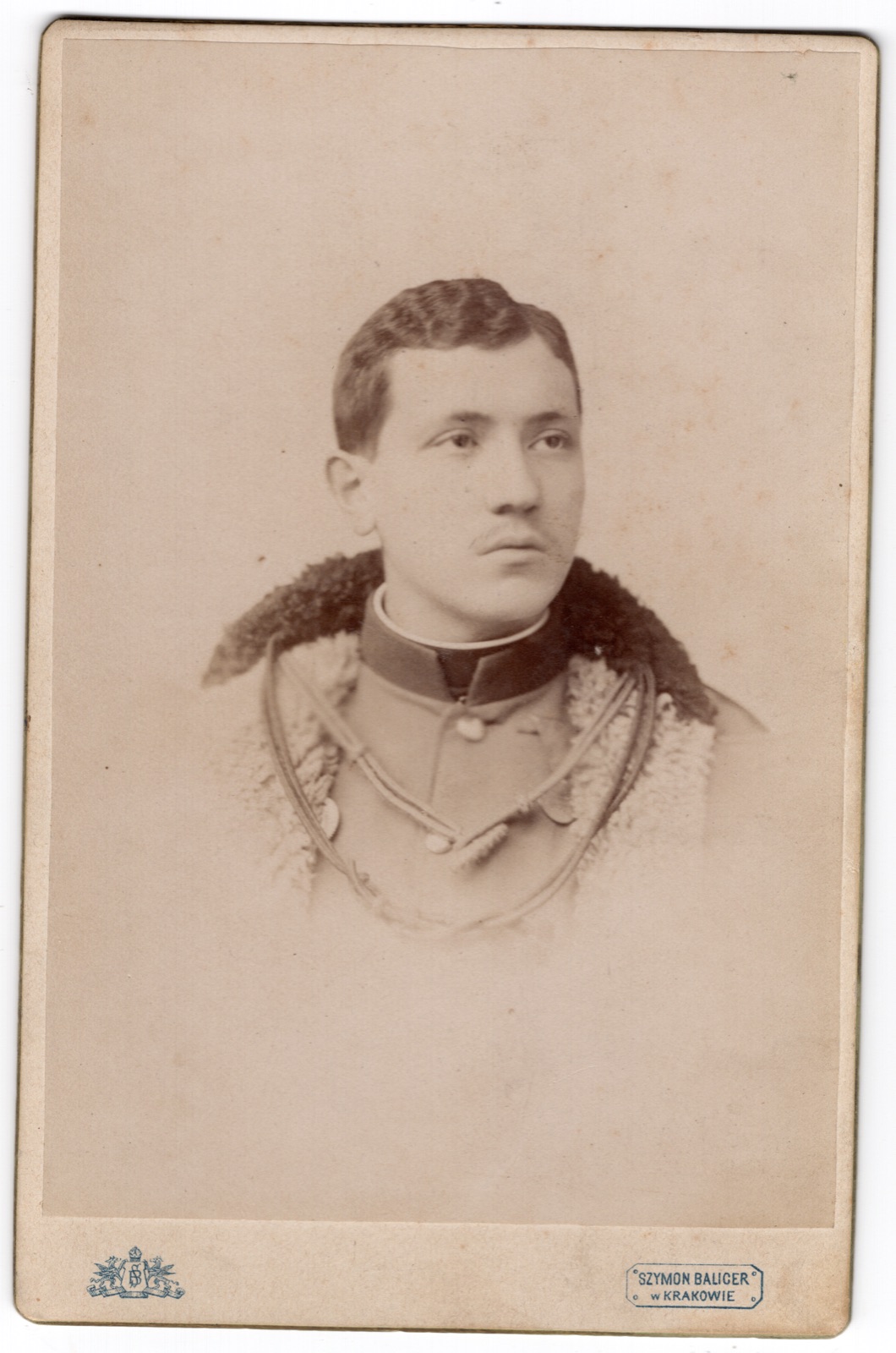 młody mężczyzna w mundurze z futrzanym kołnierzem, datowany 1899 (fotografia gabinetowa)