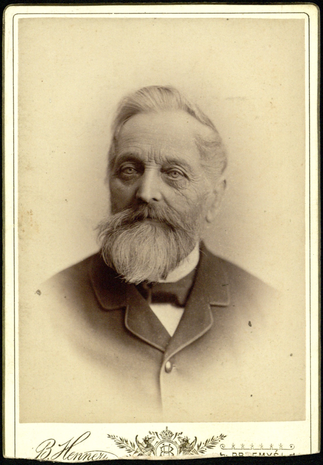 portret starszego mężczyzny z długą brodą; rewers z widokiem atelier (fotografia gabinetowa, ok. 1880–1895)